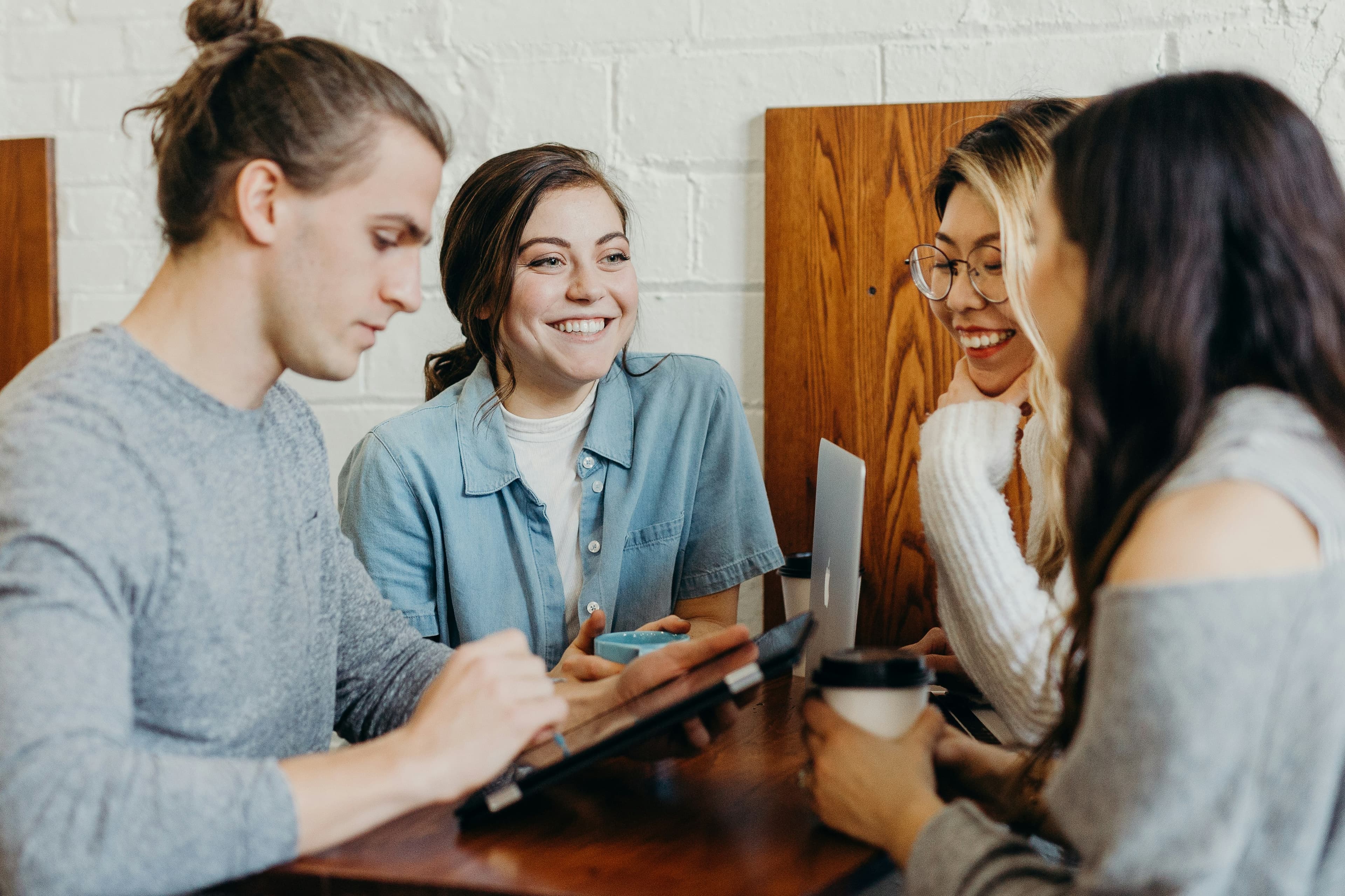 Two people sitting across a table talking, the paired setup a B1 German speaking exam uses