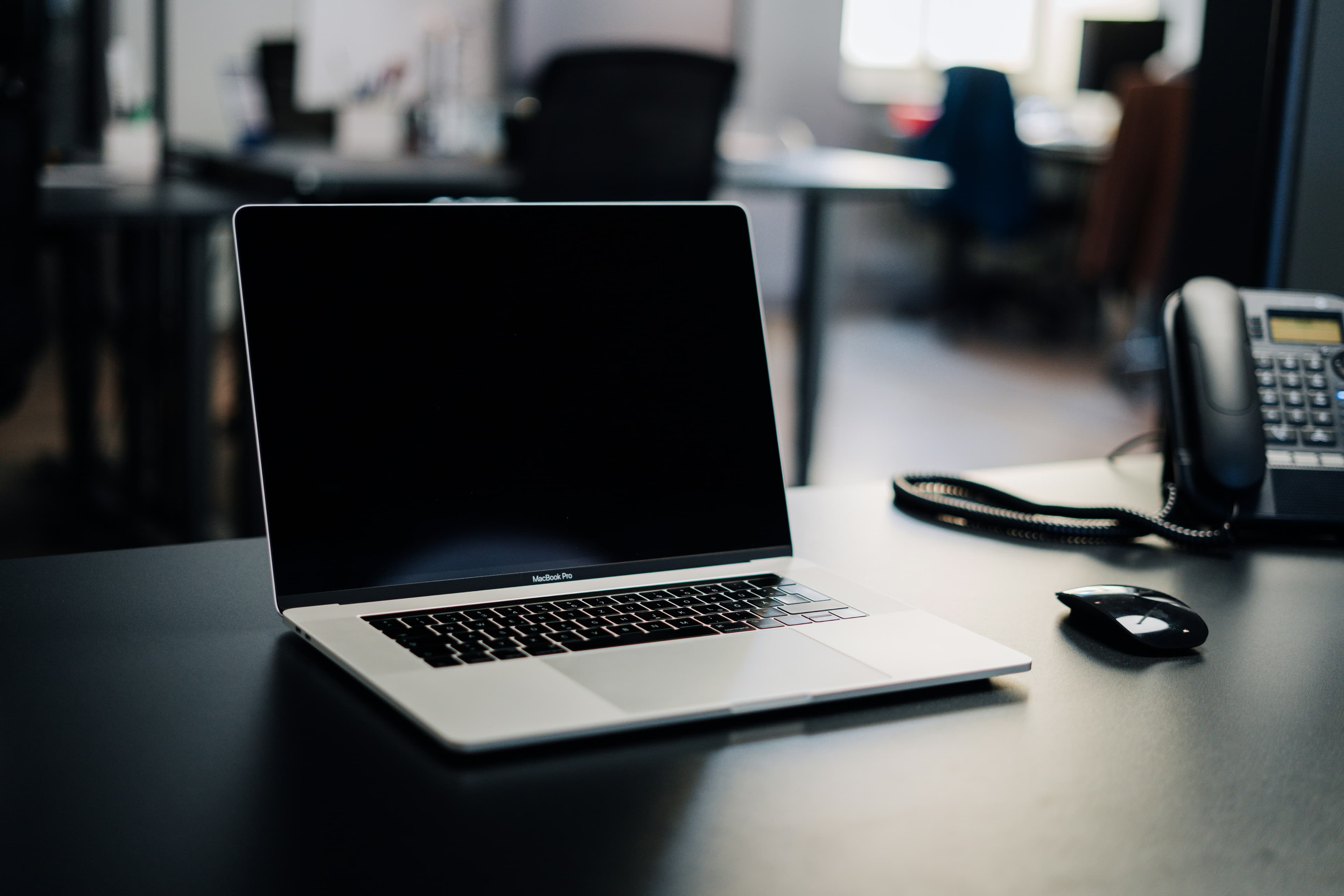An open laptop on a dark office desk, screen off, ready for the kind of one-on-one online video lesson you'd book on italki or Lingoda
